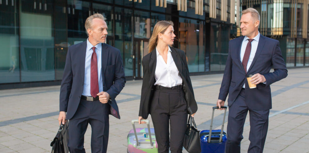 Confident businesspeople travelling with luggage